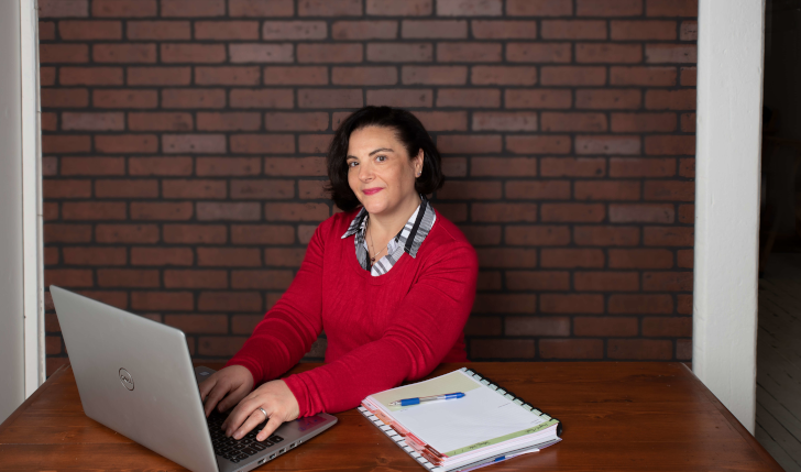 Wendy Sullivan Blue Shutters Web Design sitting at a desk