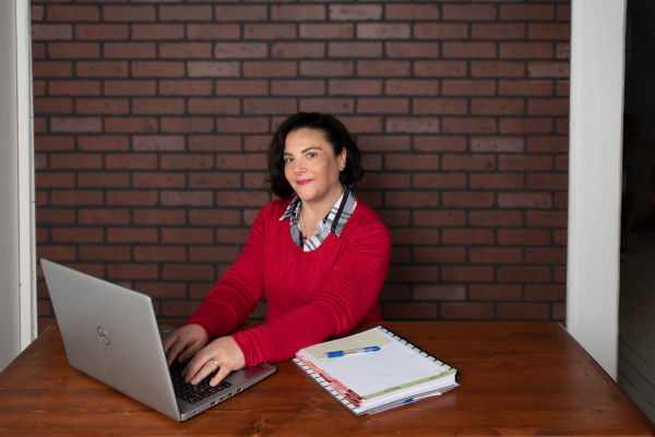 Wendy Sullivan Blue Shutters Web Desing sitting at a desk